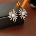 Dettaglio macro di orecchini a girasole con perle e zirconi lucidi su una scatola nera - Argento (Perno in argento) / Argento
