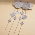 Macro detail of silver tiered disc tassel earrings on a textured stone surface - Silver (Silver Pin) / Silver