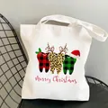 White canvas tote bag featuring cartoon teeth prints and Merry Christmas text on a chair - C3 Personified Christmas Teeth