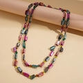 Detalle de un collar largo bohemio con cuentas de concha iridiscentes y cristales - Colorido
