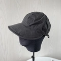 Detail view of adjustable drawstring and plastic toggle on black nylon sun hat side - Black