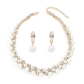 Close-up of gold alloy necklace set with elegant faux pearls and sparkling rhinestones - Gold