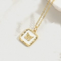 Close-up of golden necklace featuring a white square pendant with a detailed gold butterfly - White Butterfly
