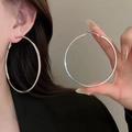 Detailed view of silver twisted geometric hoop earrings on model and handheld close-up - 32# Oversized Simple Bright Silver Hoop - 69mm