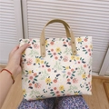 Detailed view of floral canvas tote bag with brown faux leather handles and metal rivets - Beige Base Orange-Pink Small Flowers