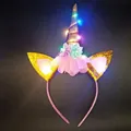LED unicorn headband with golden glitter ears and purple flowers on a black background - LED Unicorn Gold Horn