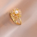 Detailaufnahme eines goldenen Blumenrings mit weißer Perle und rosa Edelsteinen auf Seide - Rosa Gold Gänseblümchen Ring