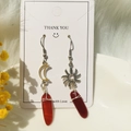 Detailed macro shot of asymmetrical sun and moon wire-wrapped quartz earrings - Red Agate