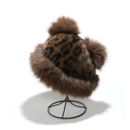 Detailansicht der Kunstpelz-Wintermütze mit Leopardenmuster und flauschigen Pompons - M (56-58cm) / Klassisches Braun Leopard (C)