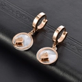 Roségouden vlinder oorbellen met witte schelpinleg op zwart getextureerd leer - Roségouden oorbellen witte schelp