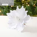 White fabric Christmas flower decoration with silver sequins on a lighted tree background - White