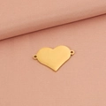Conector de corazón en oro pulido para creación de joyas sobre fondo de tela rosa - Dorado