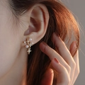 Close-up of starburst pearl earrings with zircon accents on model ear - Star Cross Zirconia Pearl (MY34312)