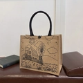 Natural linen tote bag with black woven handles and minimalist rustic line art - House
