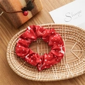 Close-up of a red Christmas scrunchie with reindeer and snowflake patterns in a basket - Basic Style / Christmas Reindeer