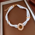 Dettaglio di collana di perle a doppio strato con pendente occhio di tigre in scatola bruna - Collana (Oro-Bianco-Marrone)