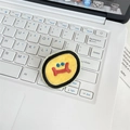 Macro detail of cartoon monster embroidery patch on laptop keyboard background - Egg Yolk Yellow