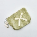Detail view of light green lace cosmetic bag with polka dots and ruffled edges - Green