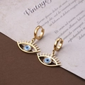 Elegante goldene Edelstahl-Ohrringe mit bösem Blick Anhänger auf Vintage-Hintergrund - Teufelsauge (ER-24)