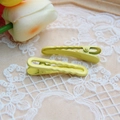 Macro shot of two yellow wavy metal hair clips resting on elegant beige lace fabric - 1.2x4.9cm / Yellow-Wave