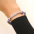 Detail of handmade ceramic bracelet with blue floral beads and NANA letter charms - NANA Letter Style (A-1094)