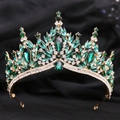Close-up of luxury bridal crown with emerald crystals and golden leaf details on velvet - Gold Clear and Green Rhinestone