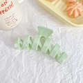 Detail of mint green matte hair claw clip with geometric hollow design on white paper - Creamy Green
