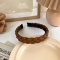 Braided brown PU leather headband for women shown on a ceramic dish with minimalist decor - Style 2 / Brown