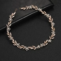 Rose gold bridal headband featuring handcrafted metal leaves, crystals, and pearls on black - Rose Gold
