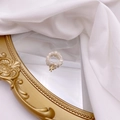 Macro detail of natural freshwater pearl ring with golden letter F charm on a mirror - Letter K