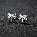 Macro shot of silver stainless steel dragonfly stud earrings with hollow wing details - 108 Dragonfly / Steel