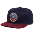 Detail of embroidered Olympic National Park patch on navy and burgundy flat brim cap - Navy Crown Red Flat Brim / Navy Blue