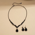 Flat lay of vintage style black crystal teardrop necklace and matching earrings set - Black