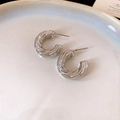Detailed macro view of silver C-shaped hoop earrings with a twisted rope texture finish - Silver Twisted Texture C-Shape
