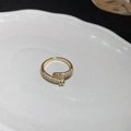 Vergoldeter offener Nagelring mit Zirkonia-Besatz auf weißer Keramikplatte - Nagelumwickeltes Gold (56#)