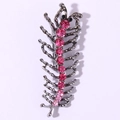 Macro detail of centipede brooch with pink rhinestones on dark grey metal surface - Rose Red