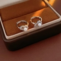 Detailed close-up of zircon hollow gourd earrings with pearls in a luxury jewelry box - Hoop Earrings-Silver