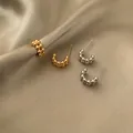 U-shaped beaded stud earrings set in polished gold and silver finish on silk fabric - Gold