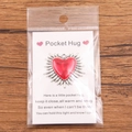 Pocket Hug Heart gift with red enamel charm and inspirational poem card on wooden background - Red and Silver Heart