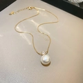 Gold plated necklace featuring a white faux pearl and a clear zircon pendant on a fine chain - Gold and White Pearl Necklace