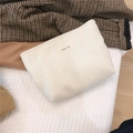 Detailed macro view of a cream white woven cosmetic pouch with simple wish cloth label - White