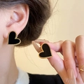 Elegant heart earrings in black and gold finish shown on ear for size reference - Black Heart Stud Earrings (G198)