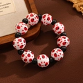 Détail du bracelet perlé avec motifs coccinelle et cœur sur fond en cuir sombre - Motif Coccinelle (Blanc)
