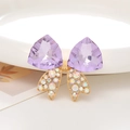 Vue macro détaillée d'un nœud en cristal violet avec strass AB et alliage doré élégant - Violet