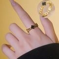 Golden chain-style adjustable ring with black four-leaf clover charm on female hand - Black Shell Clover Style (696)