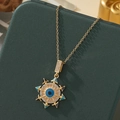 Gros plan du pendentif œil porte-bonheur doré avec émail bleu et strass scintillants - A32-or