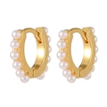 Elegantes aretes de aro chapados en oro con pequeñas perlas blancas sobre fondo blanco - Huggie Dorado de Fila de Perlas (E466)