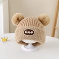 Dettaglio del cappello in maglia per neonati con bordo in peluche e due pompon e toppa CAP - 2-5 Anni / Lettere CAP / Cachi