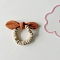 Detail of suede bow hair scrunchie with two-tone brown and beige velvet texture - Orange Bow