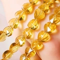 Macro shot of faceted yellow heart-shaped glass beads for jewelry making - Gold